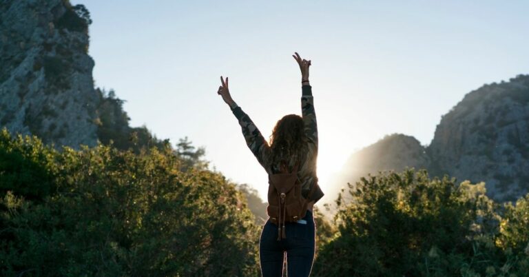woman taking in a beautiful view at the top of a mountain hike